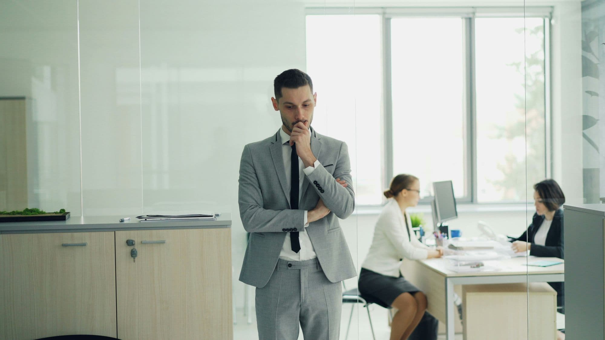 Business owner in a glass-walled office weighing finance options after a bank decline