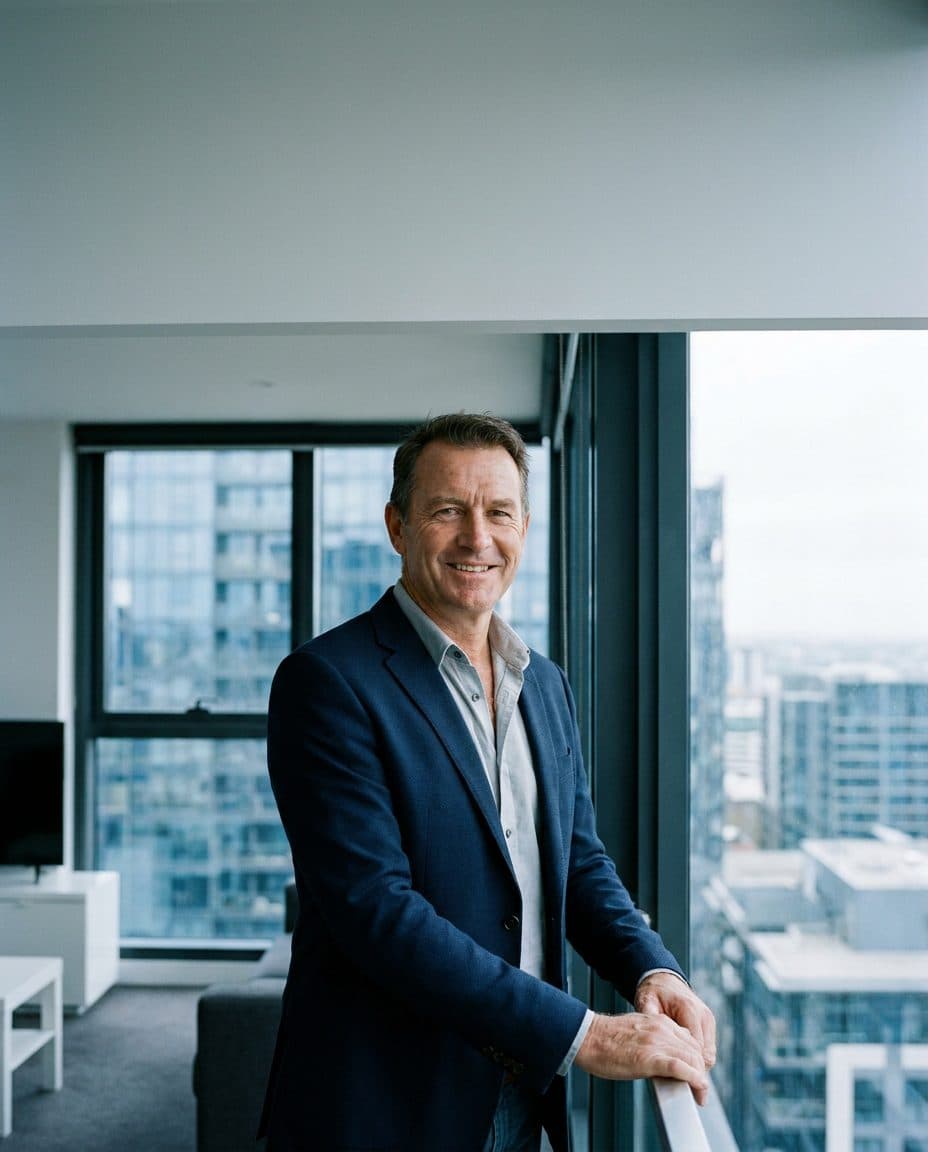 Business owner smiling on a high-rise balcony overlooking the city